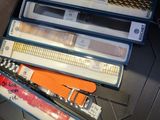 a drawer full of office supplies and a hand holding a pen