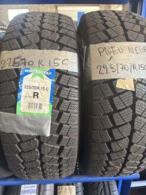 Deux pneus sont empilés sur un présentoir, avec des étiquettes de prix accrochées dessus.