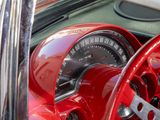 dashboard of a red car with a speedometer and steering wheel