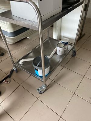 a microwave sitting on a metal cart in a kitchen