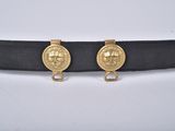 un gros plan sur une ceinture ornée de deux médaillons en or
