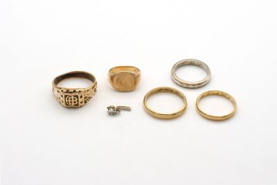 trois bagues en or et une bague en argent sur un fond blanc
