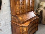un bureau en bois avec des tiroirs et un miroir accroché au mur