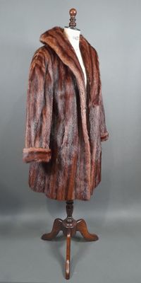 un manteau en fourrure marron et noir posé sur un pied de mannequin