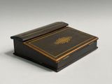 an image of a small wooden box with a gold decoration on it