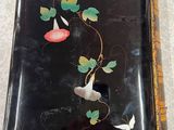 a black box with flowers and leaves painted on it