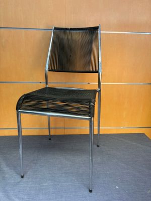 a black chair sitting in front of a wooden wall