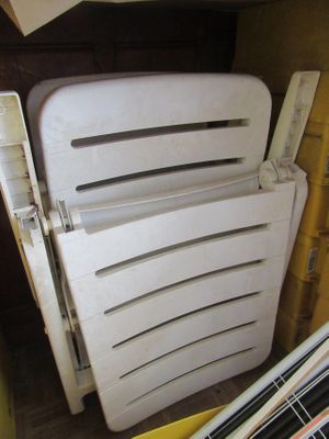 une pile de chaises en plastique dans un coin de la pièce