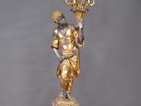 an image of a statue of a man holding a candelabra on a wooden floor
