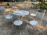 une table et des chaises posées dehors, dans la terre