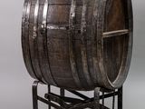 an old wooden barrel sitting on top of a metal stand