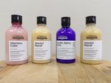 three bottles of hair products sitting on top of a wooden table
