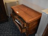 a wooden desk with a drawer underneath it in the corner of a room