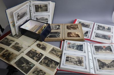 beaucoup de vieilles photos posées sur une table, à côté d'une lampe