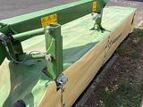 an image of a green and yellow lawn mower on the side of the road