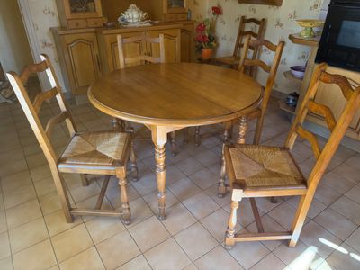 a wooden table with four chairs around it in the kitchen