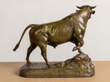 bronze statue of a bull on a rock on a table