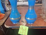 trois vases bleus posés sur une table, avec une étiquette de prix