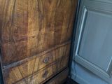 a wooden chest of drawers in the corner of a room
