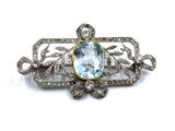an image of a brooch with a blue topaz stone