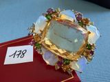 une bague en or sertie d'une grosse pierre entourée de pierres colorées