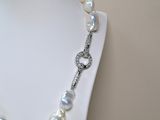 necklace with white pearls and a silver clasp on a mannequin