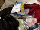 a pile of clothes and other items on a bed