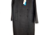 Le manteau est noir et porte une étiquette bleue.