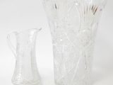 two glass vases sitting next to each other on a white surface