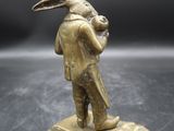 une figurine ancienne en laiton représentant un homme avec un lapin sur la tête