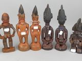 several wooden figurines are lined up in a row on a white surface