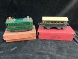 two toy trains sitting on top of boxes on a black surface