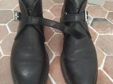 pair of black leather shoes with buckles on a brick floor