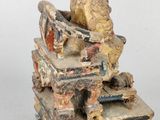 statue of a man sitting on a pile of books with a crown on his head