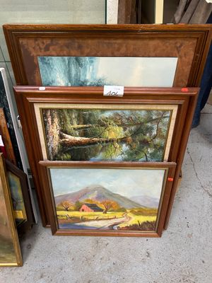 Deux tableaux encadrés représentant un paysage de montagne sont exposés devant un bâtiment.