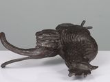 an elephant statue sitting on top of a white table next to a gray wall