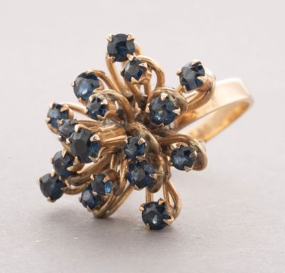 a close up of a gold ring with blue sapphires