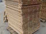 plusieurs piles de bois empilées les unes sur les autres dans un entrepôt