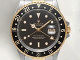 a rolex watch with a black dial on a gold bracelet