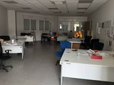 une salle où se trouvent de nombreux bureaux et chaises