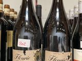 plusieurs bouteilles de vin sont alignées sur une étagère