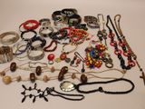 many different types of necklaces and bracelets laid out on a table