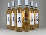 four bottles of wine are lined up on a white surface