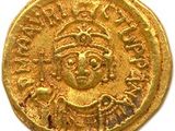 une pièce d'or à l'effigie d'un homme coiffé d'une couronne