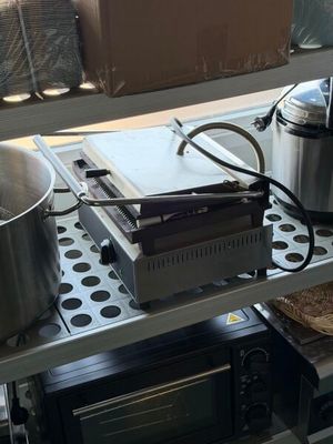 deux casseroles et une poêle posées sur une étagère à côté d'une cuisinière