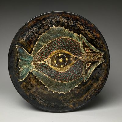 a close up of a plate with a fish design on it