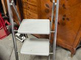 a metal step stool with two steps on top of it