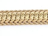 a close up of a gold chain bracelet on a white surface