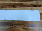a white license plate sitting on top of a wooden table