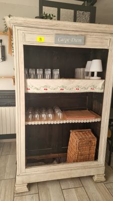 une armoire sur laquelle sont posés des verres, dans une pièce